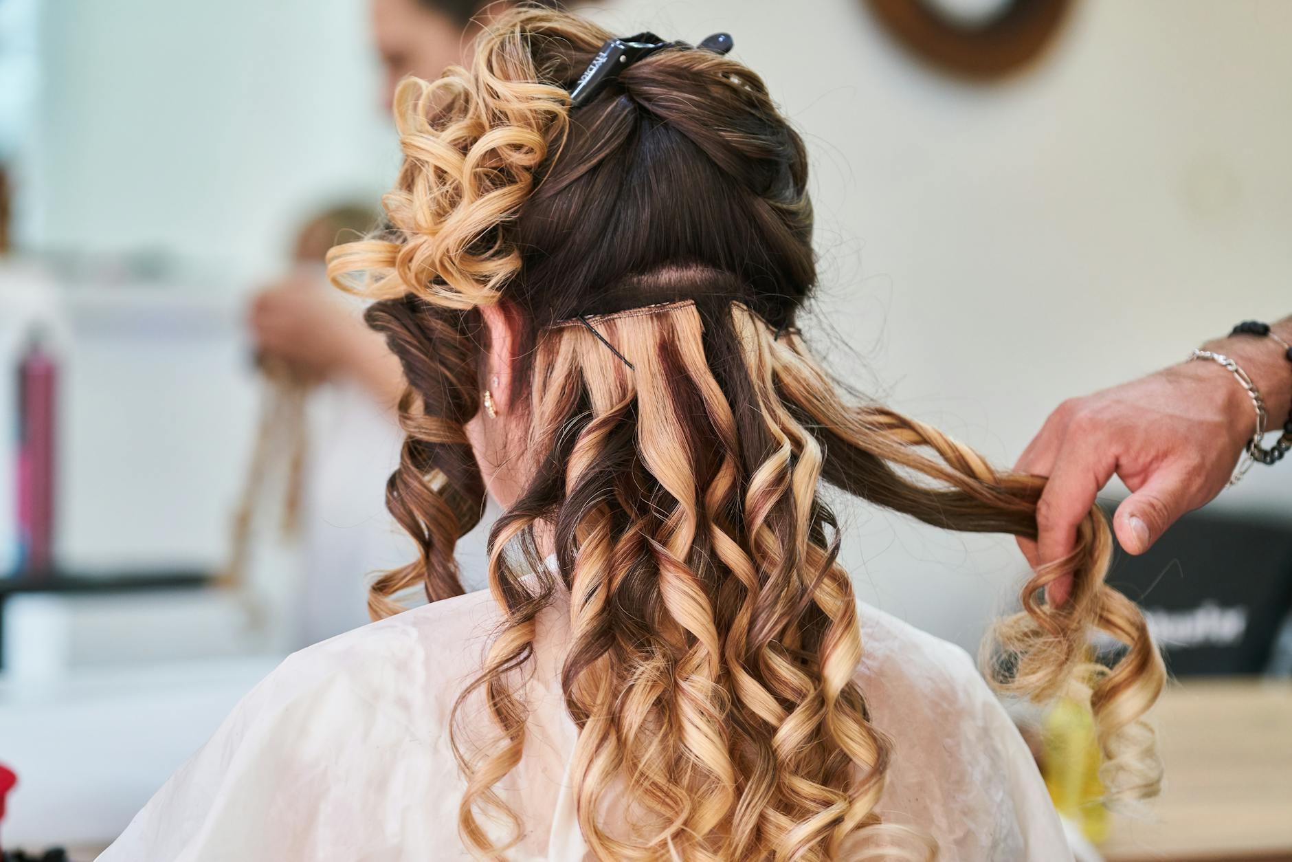 Hairstylist creating beautiful curls at a professional salon